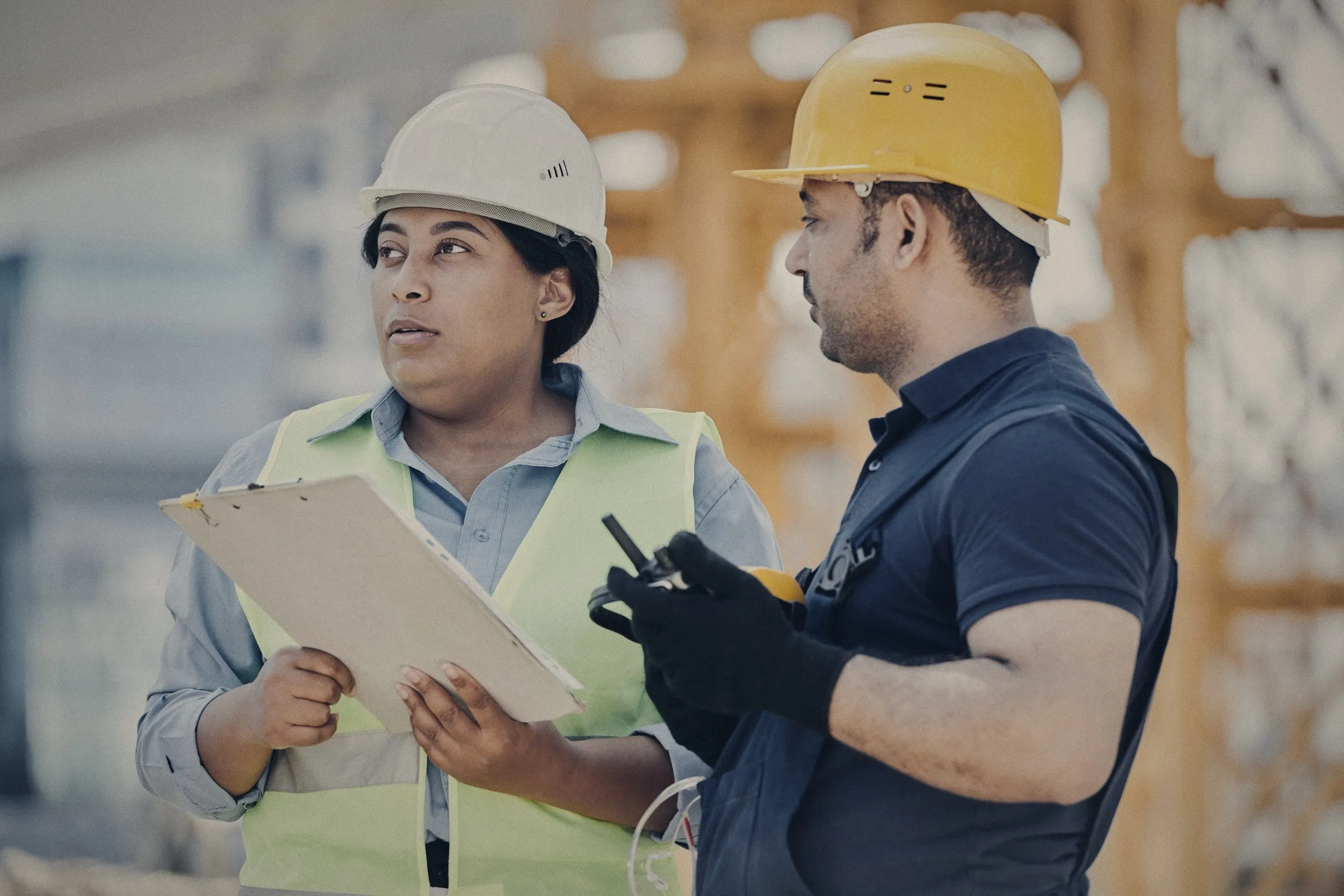 Ingenieros con casco revisando planos en una obra