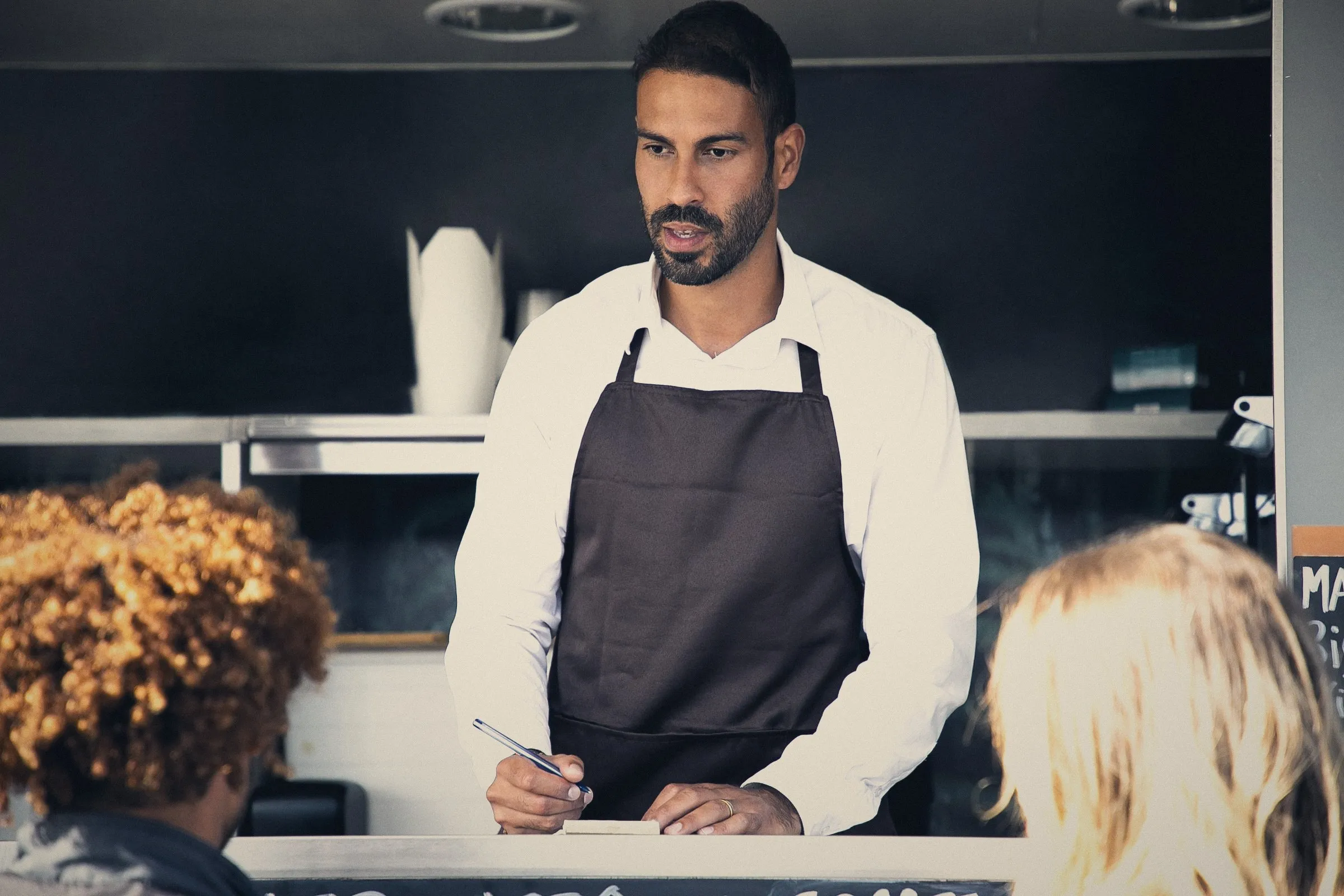 Dueño de un negocio de comidas atendiendo a sus clientes