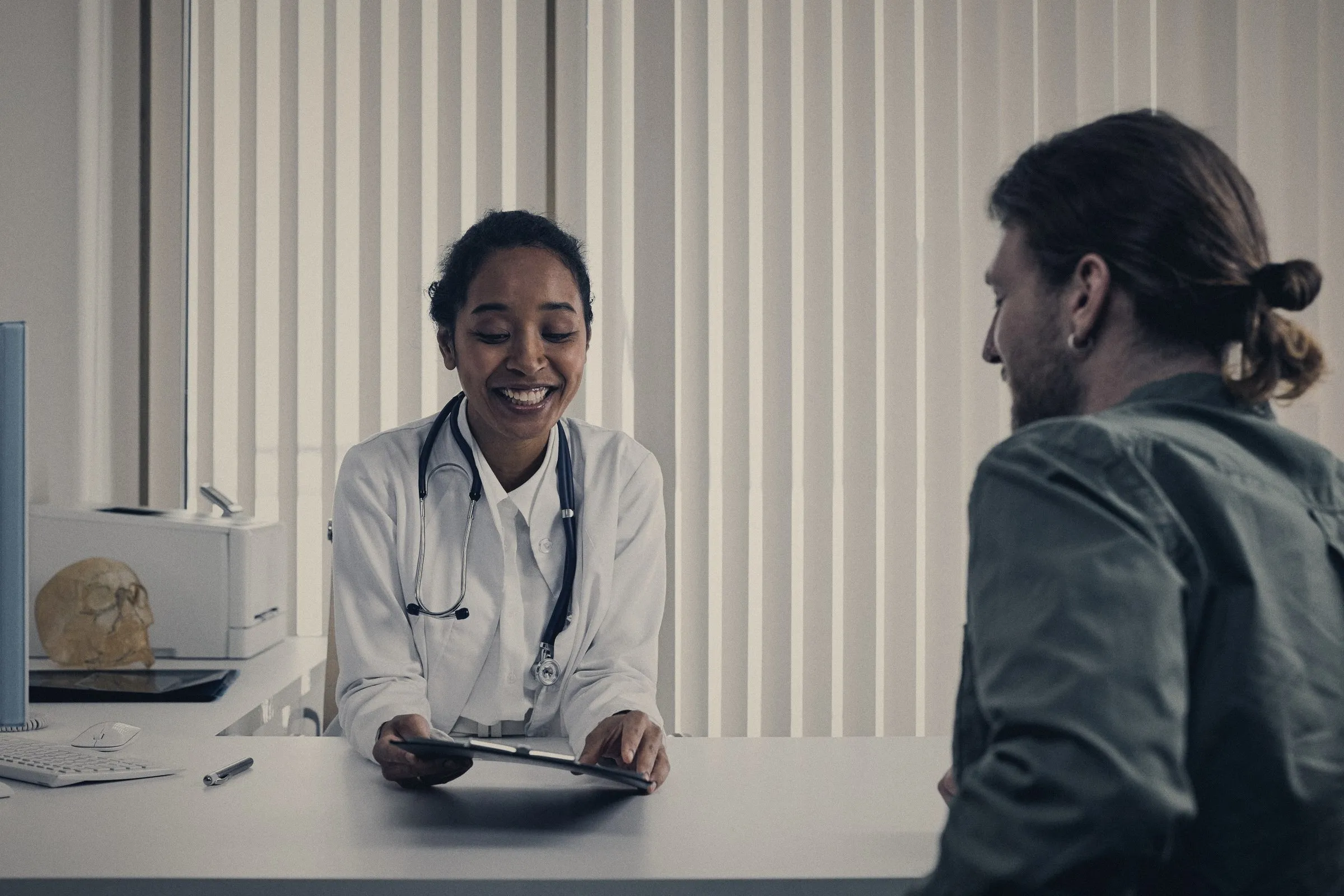 Médica atendiendo a un paciente en un consultorio