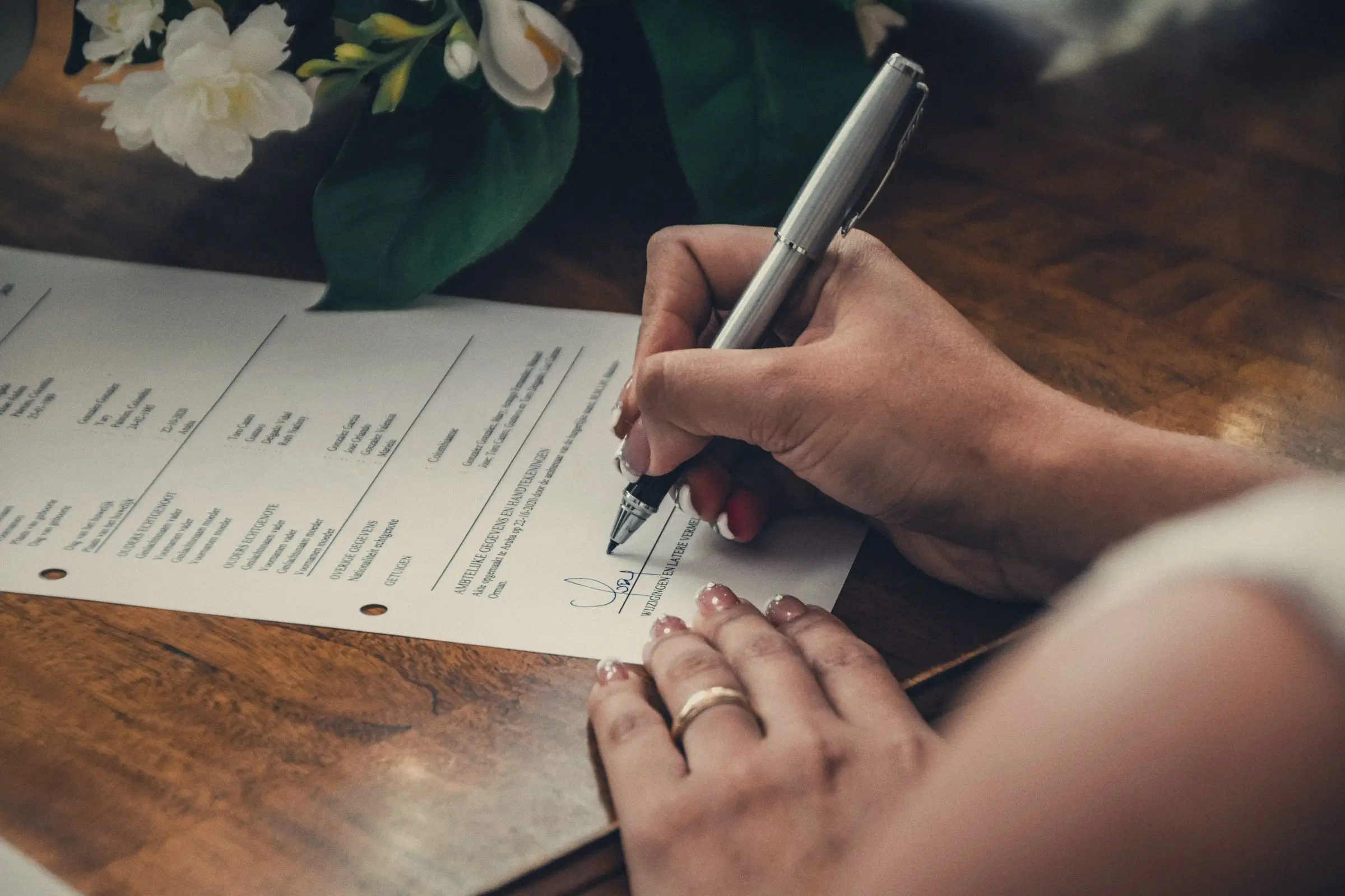 Persona firmando un formulario sobre una mesa